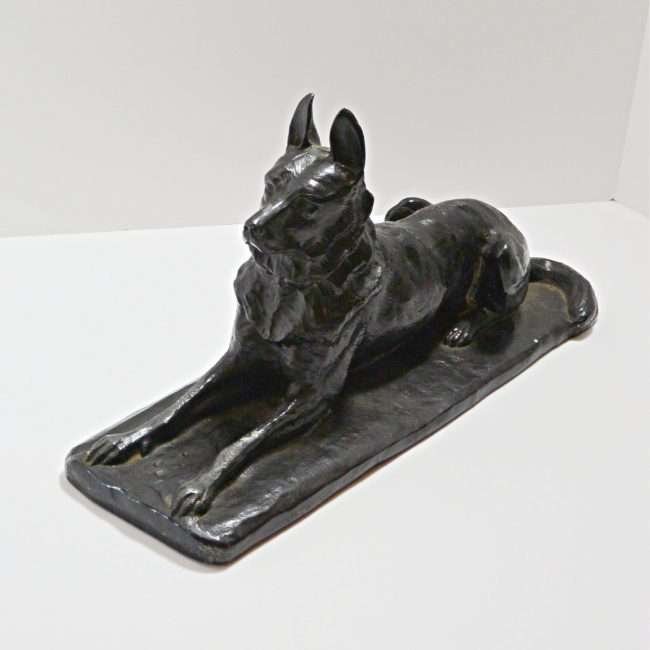 german shepherd figurine lying down